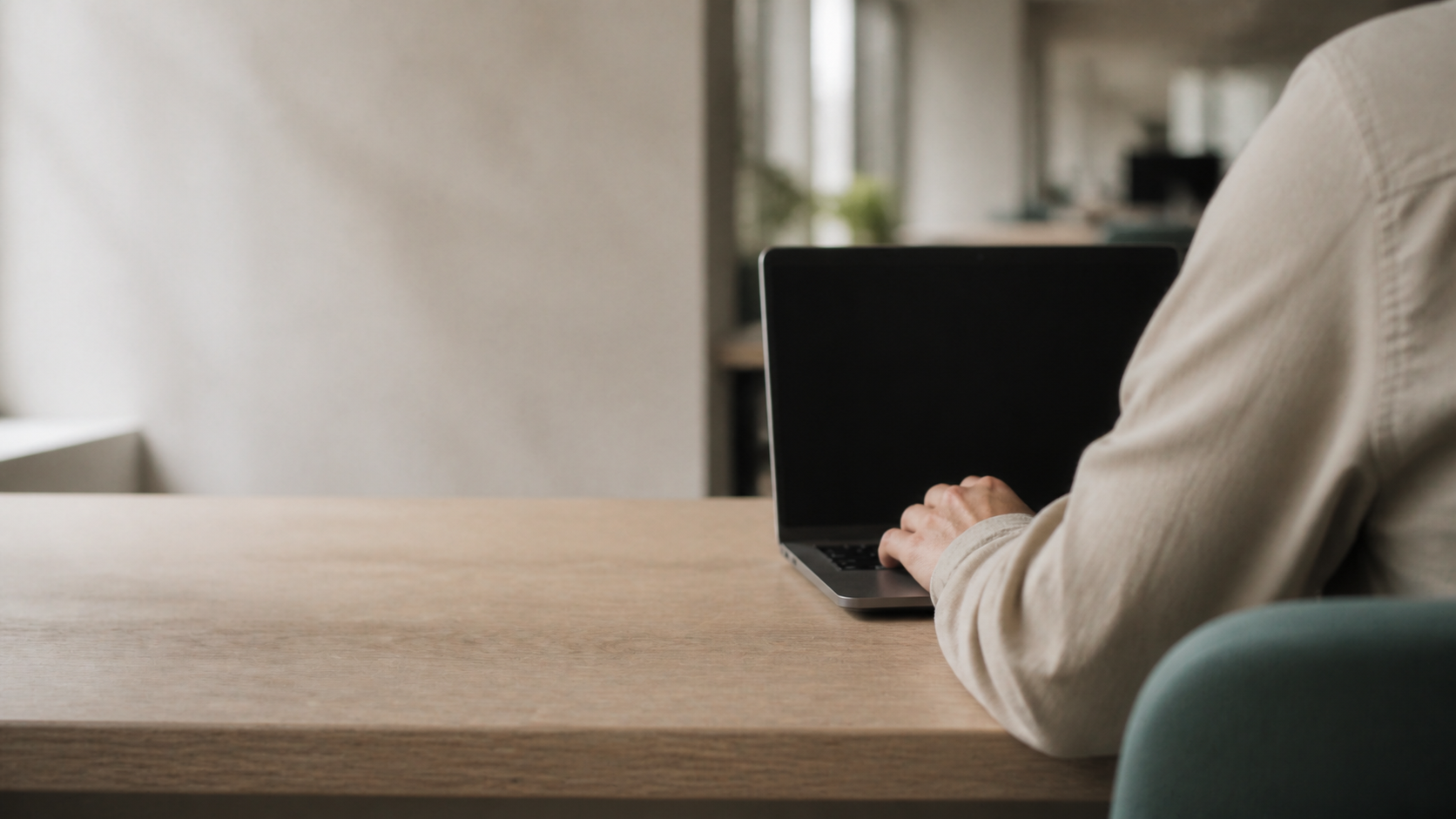 Professional seen from behind with a resting hand on an unreadable laptop